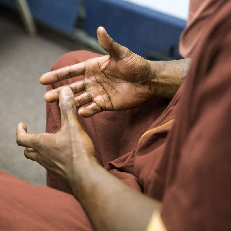Closeup of a prison inmate's hands during a support group meeting.